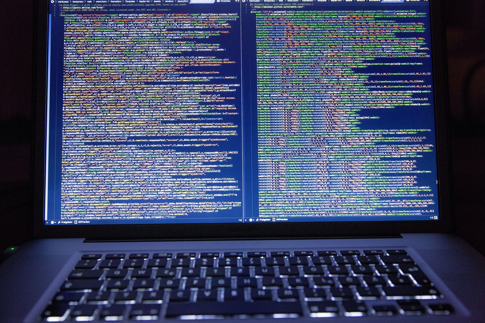 A photograph of a laptop screen displaying full pages of code.